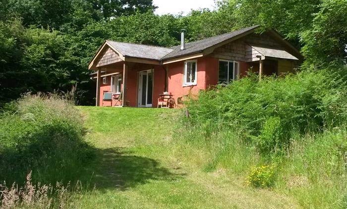 Outside of the cottage with veranda with table and chairs, BBQ and panoramic views